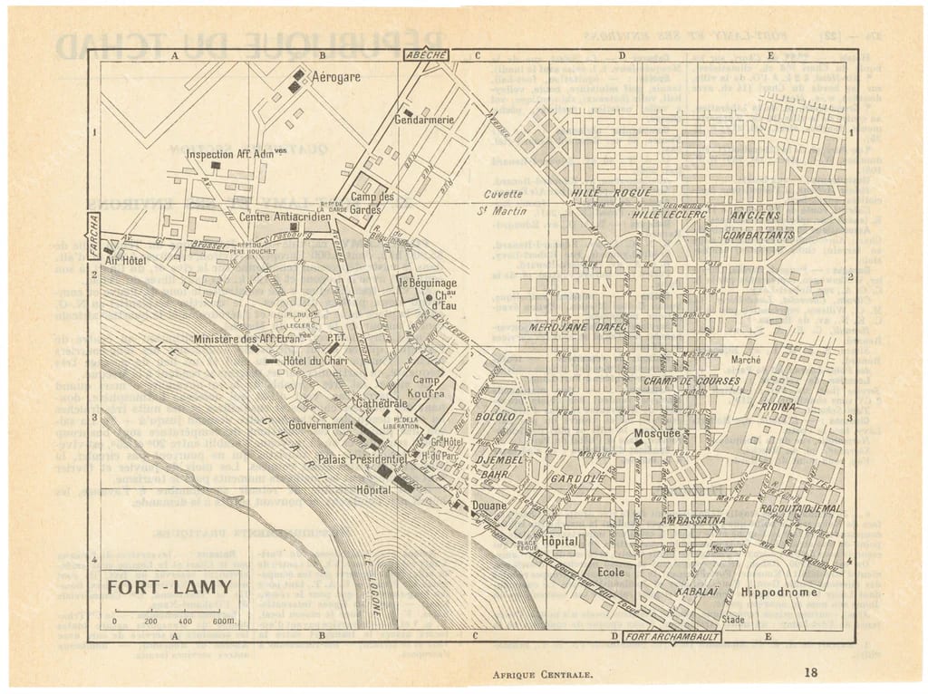 A 1962 aerial view of a low colonial town of tree-lined avenues on a flat riverside plain
