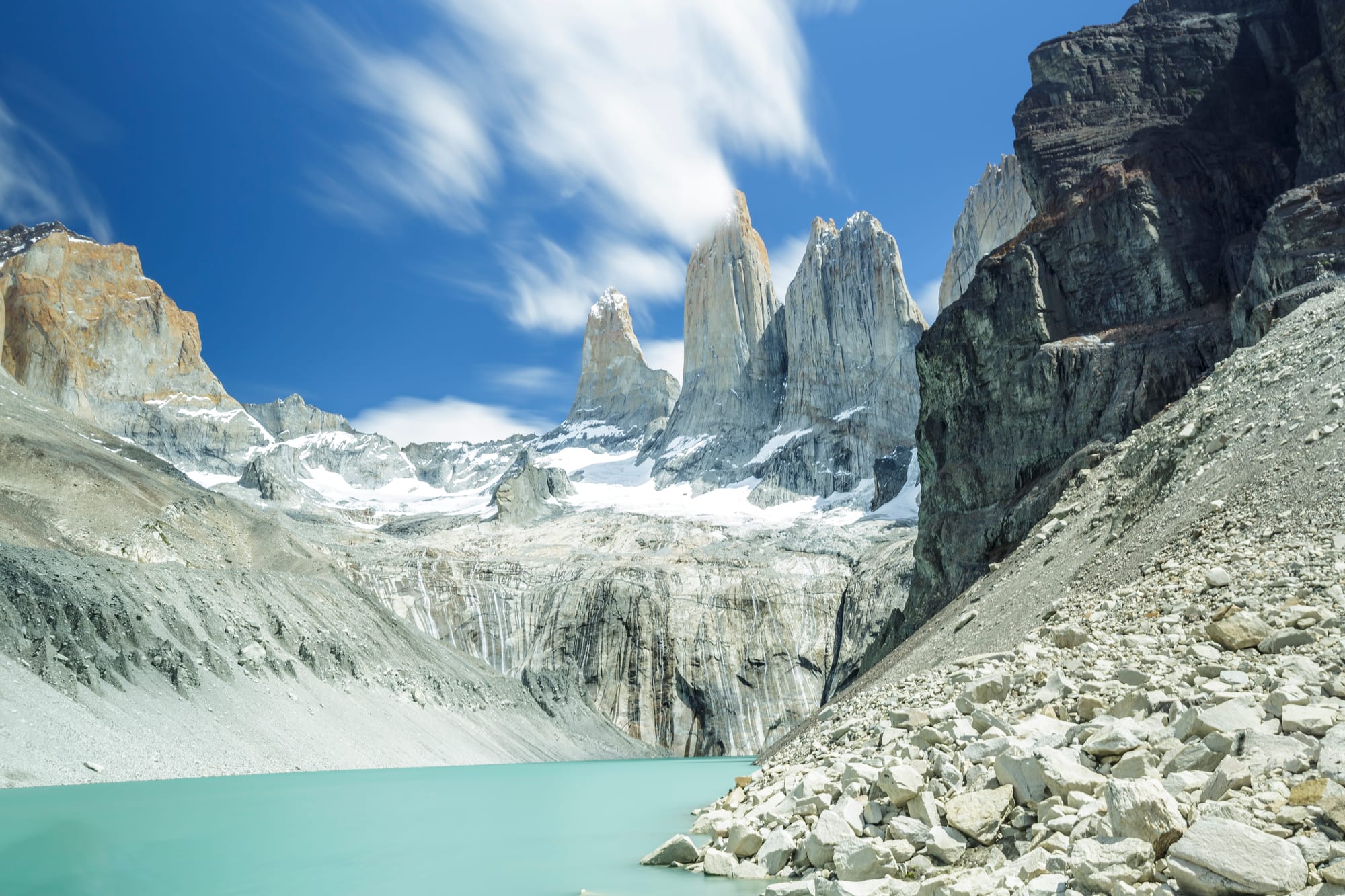 Jagged black-capped granite peaks above golden Patagonian grassland and a lake