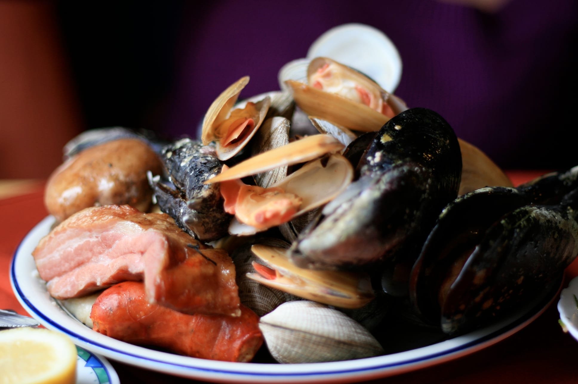 A large mixed plate of shellfish, smoked meat, chicken, sausage and potato breads