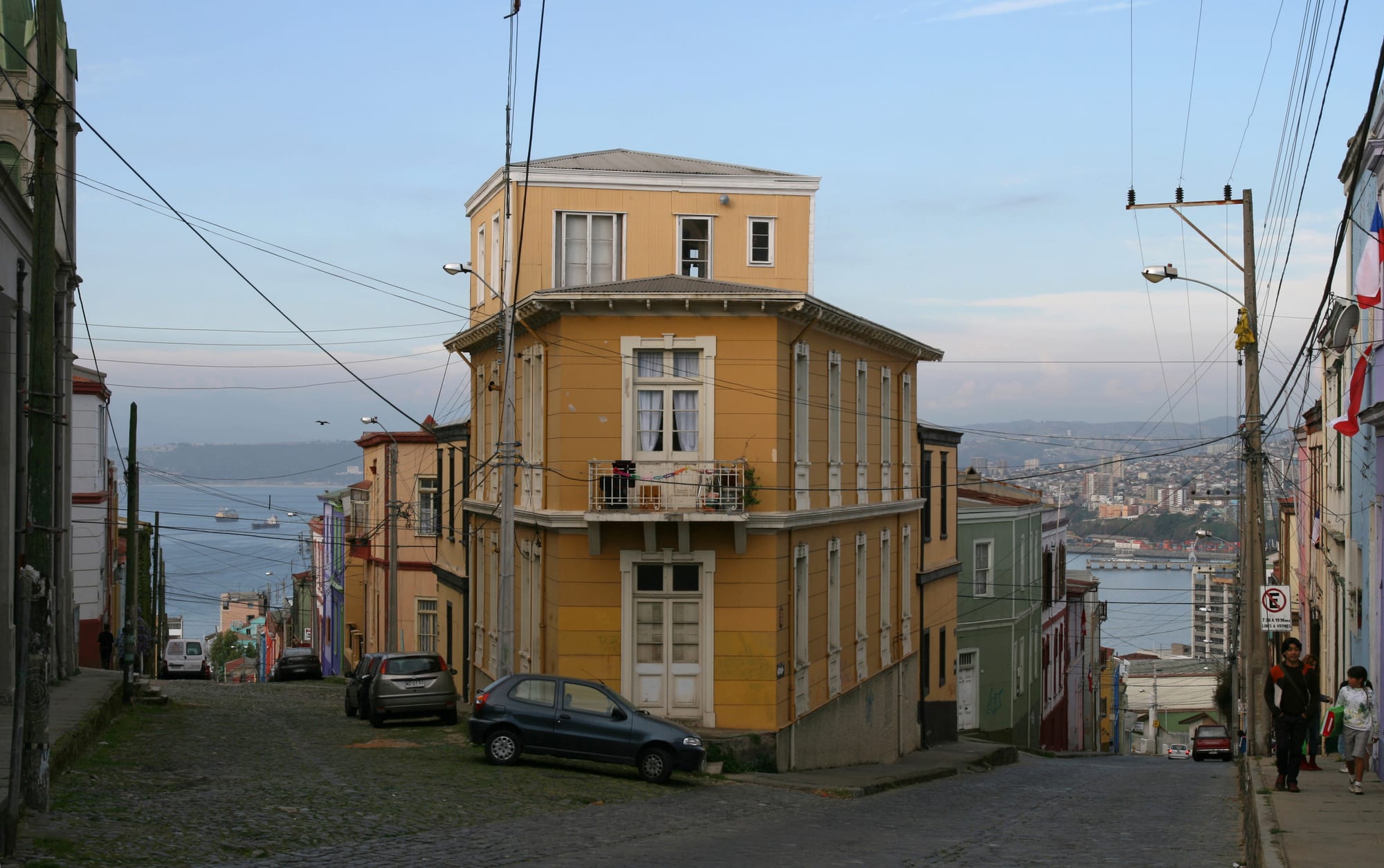 Steep streets of colourful houses and a funicular climbing a hillside above a Pacific port
