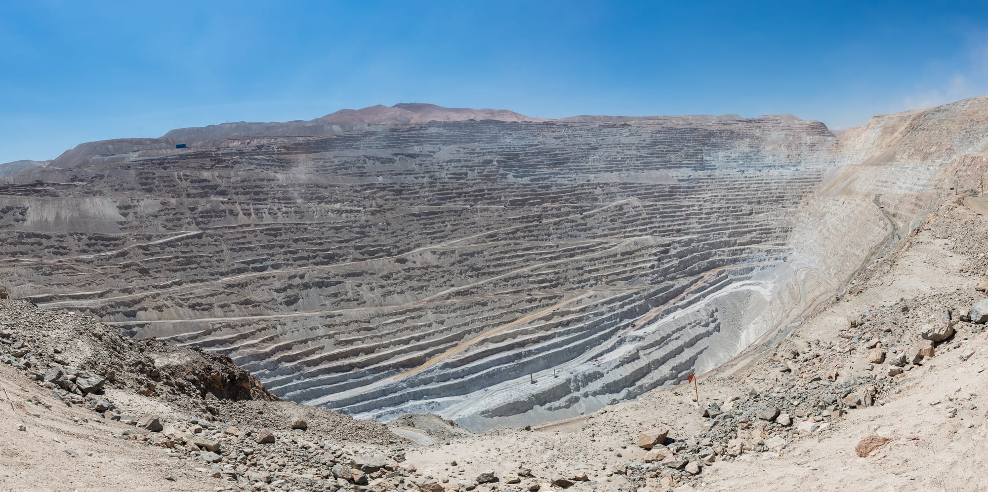 An immense terraced open-pit mine cut in steps hundreds of metres deep into the desert
