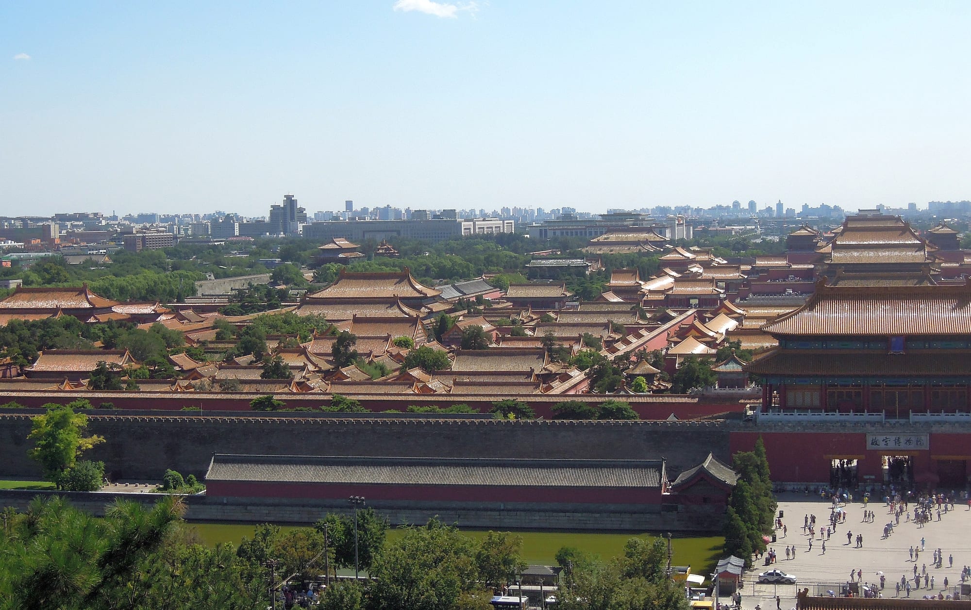 A vast walled complex of golden-roofed halls and courtyards in the centre of a modern city