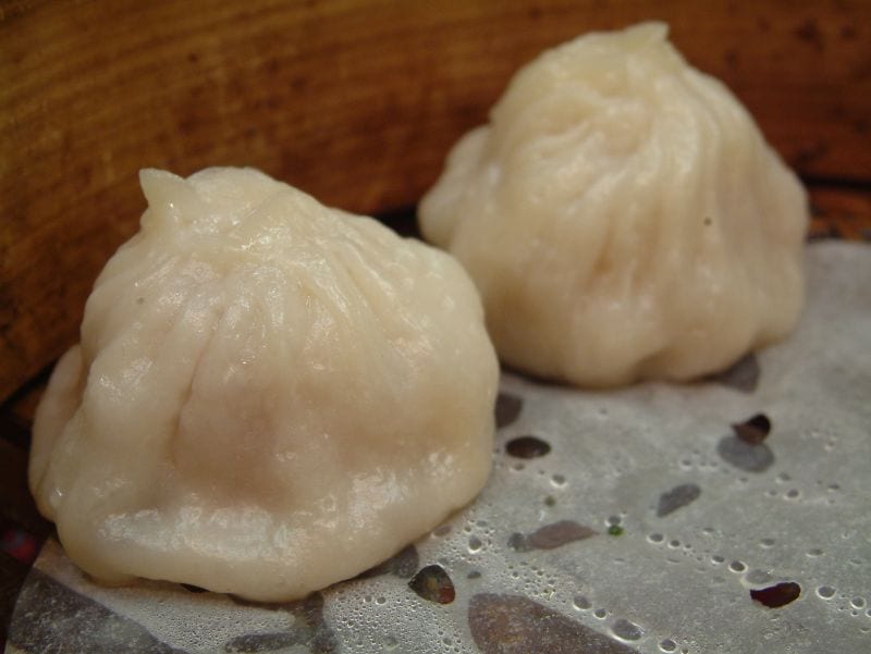 Small pleated dumplings in a bamboo steamer