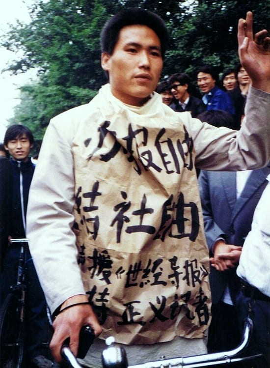 A crowd of student protesters with banners marching in Beijing in 1989