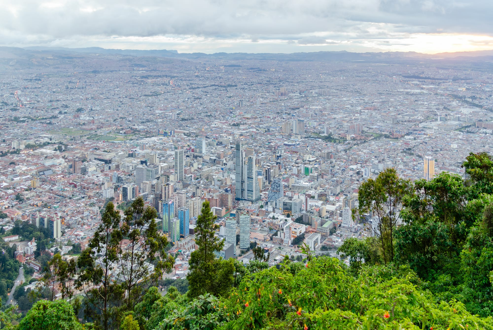 A white church on a green mountain summit high above a vast city on a plateau