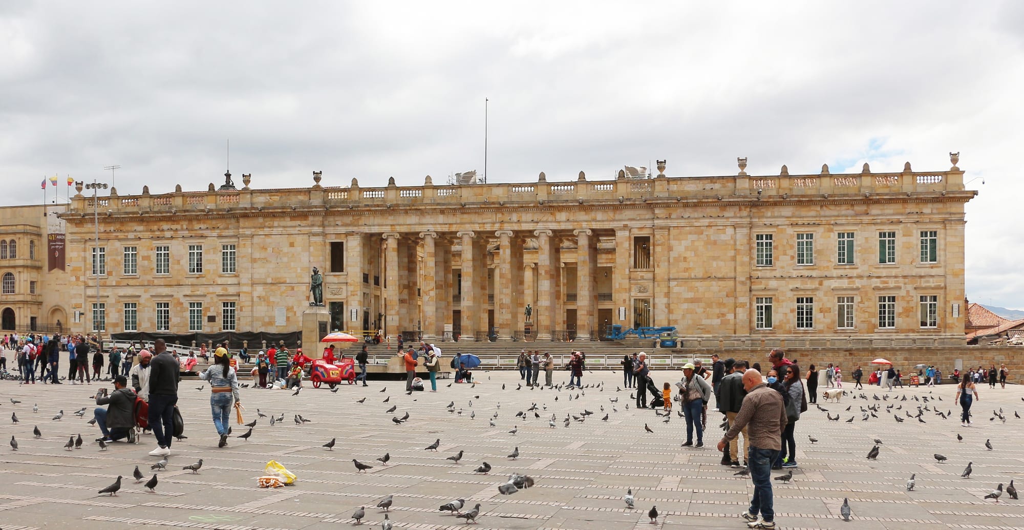 A long neoclassical stone congress building with a columned portico, facing a large plaza