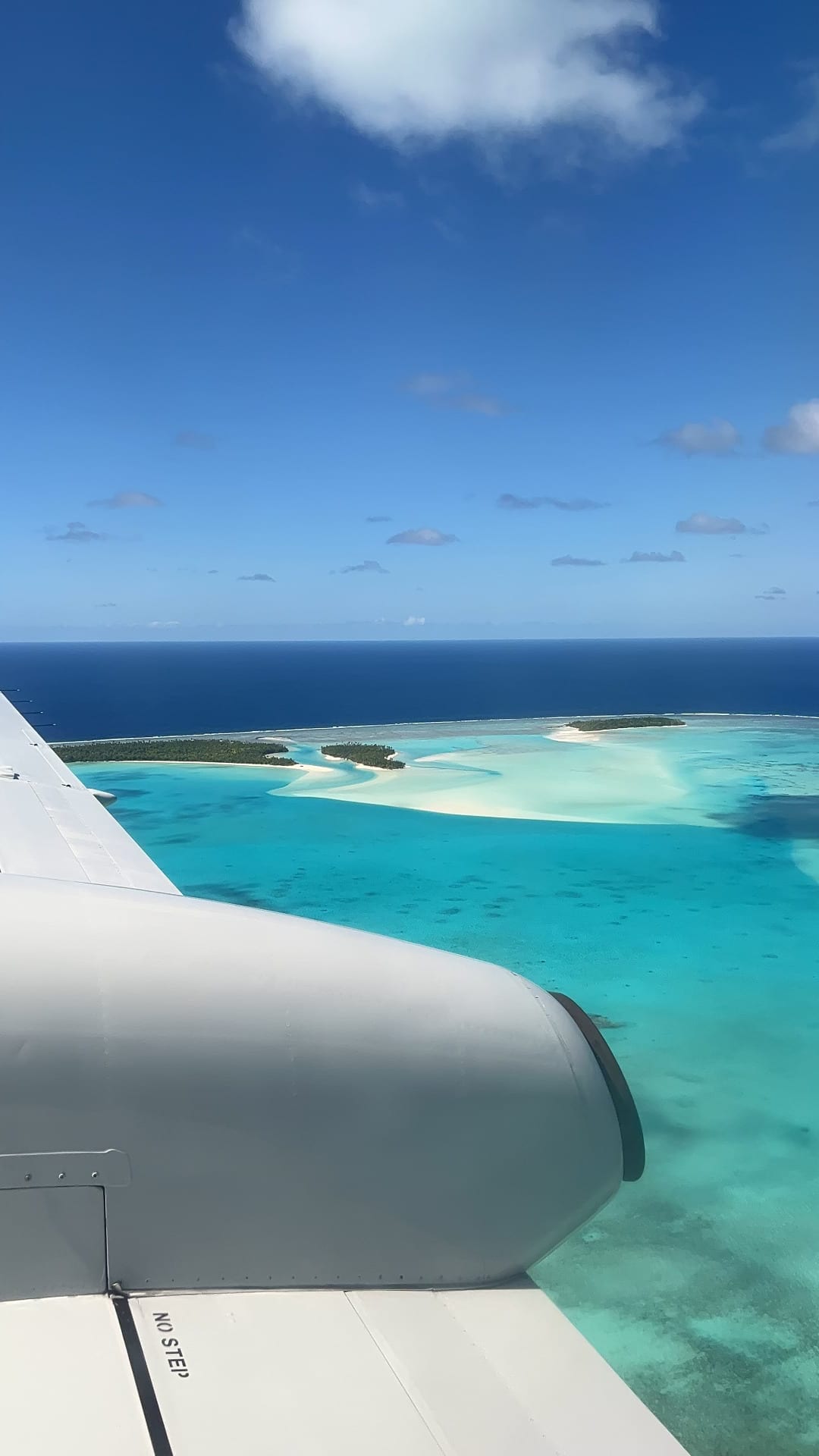 A triangular turquoise lagoon dotted with sandy islets, ringed by a reef
