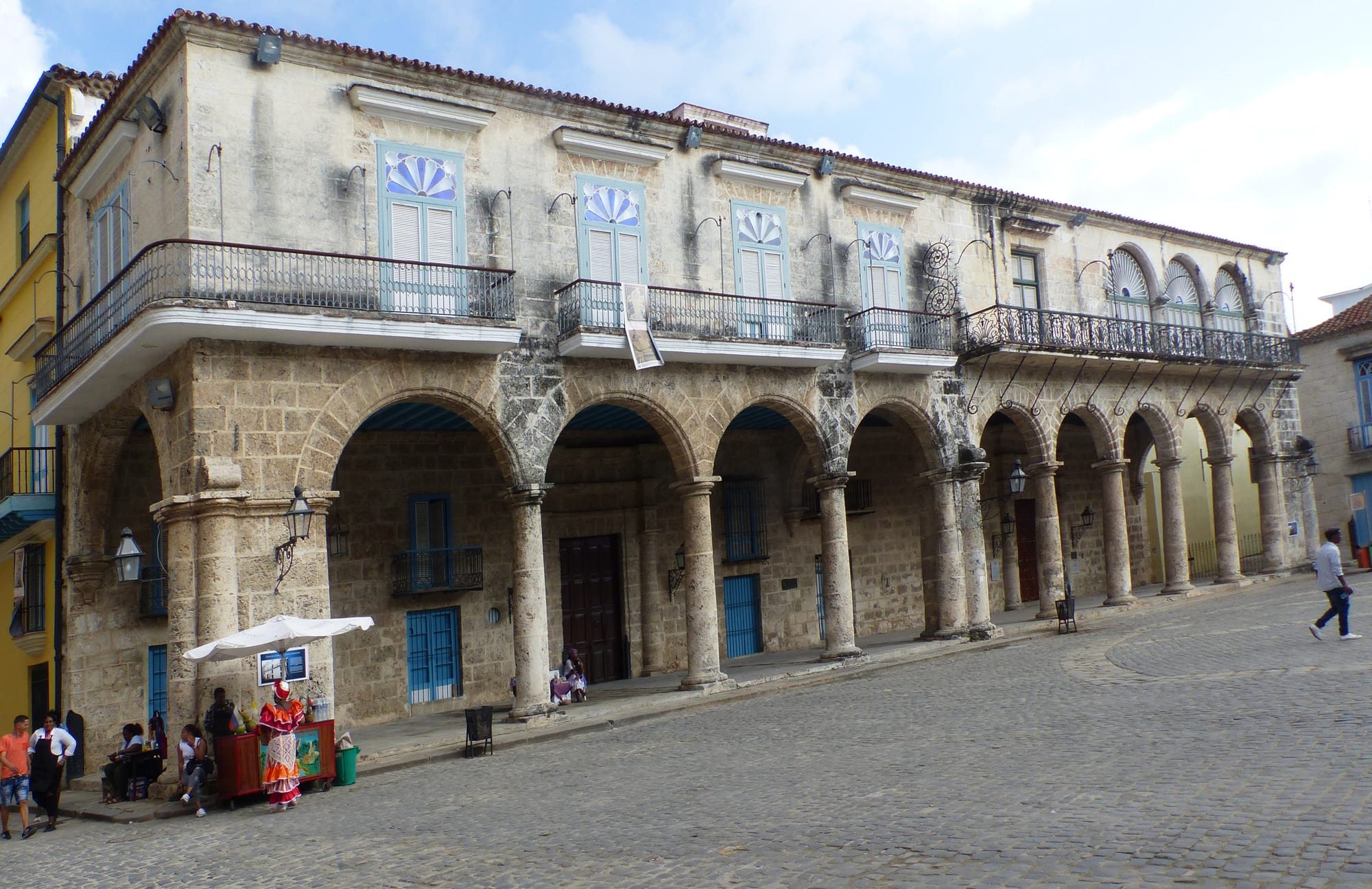 A baroque stone cathedral with asymmetrical towers on a small cobbled colonial square