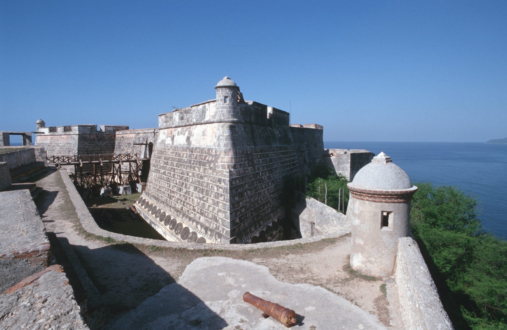 A stepped stone fortress on a headland guarding the narrow entrance to a bay