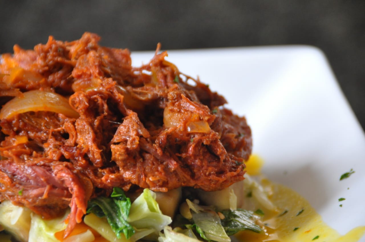 A plate of shredded beef in a red tomato-based sauce