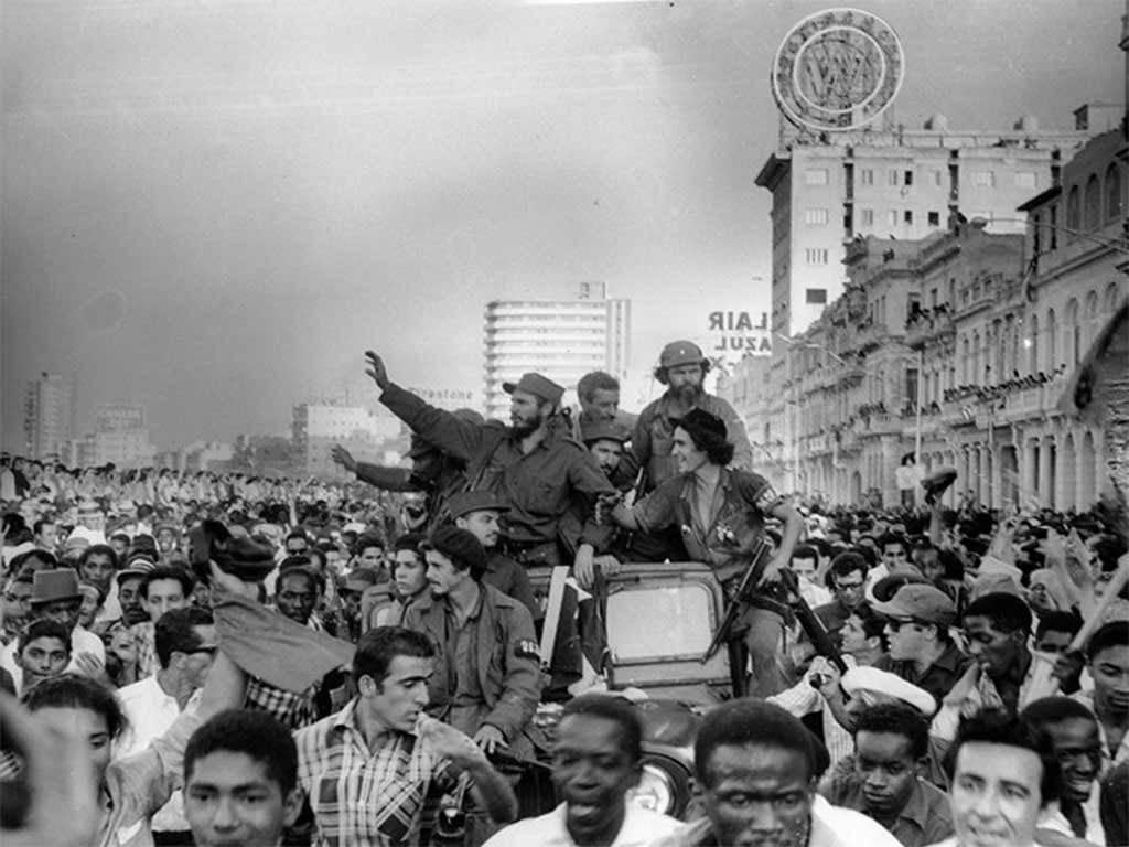 Bearded guerrillas riding tanks and trucks through crowds of cheering people, January 1959