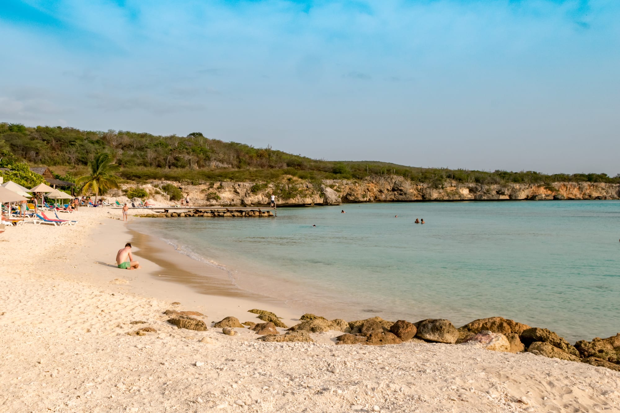 A calm beach with clear shallow water over a reef, seen from the air