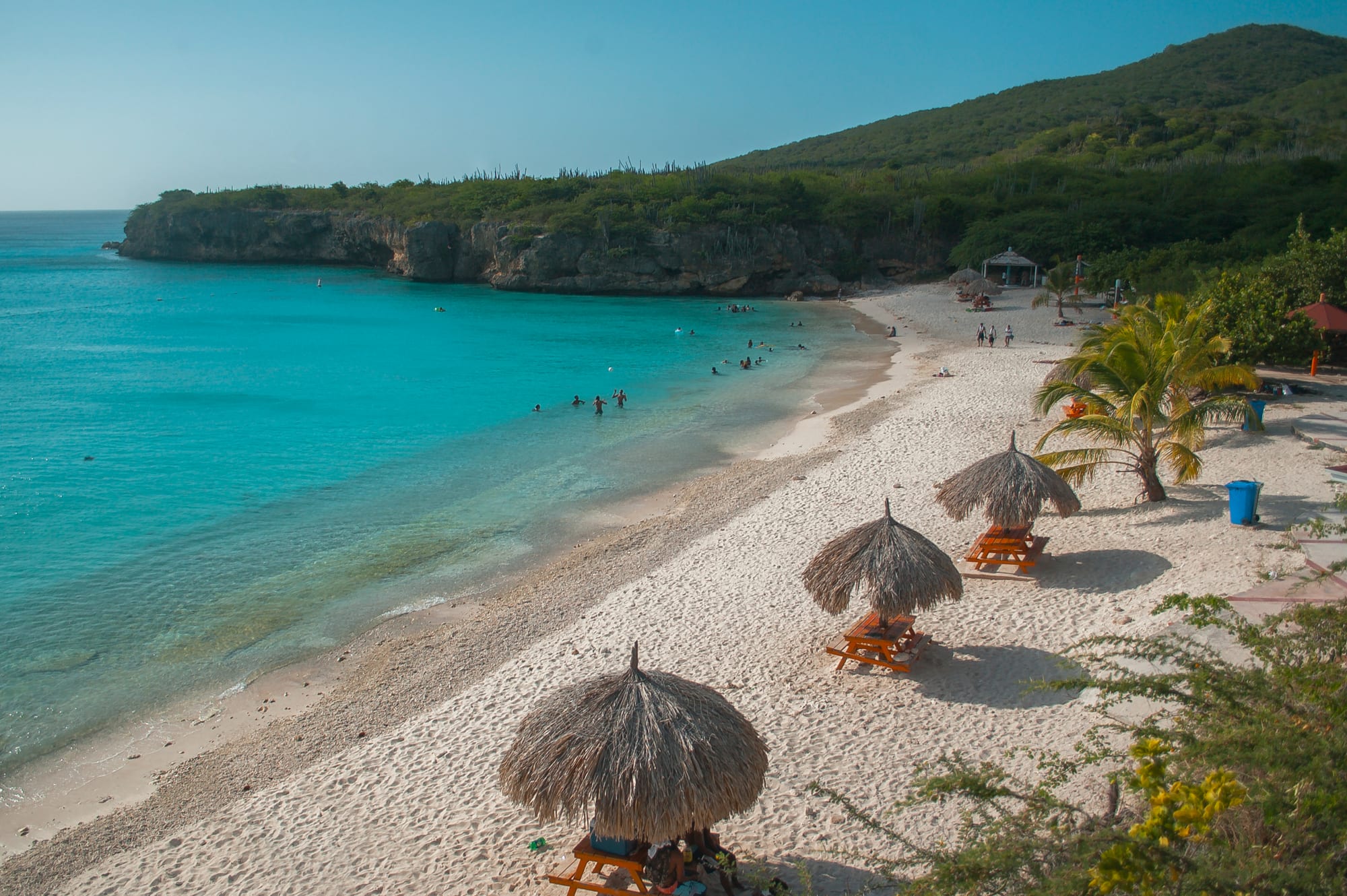 A small cove of pale sand and vivid turquoise water backed by low cliffs