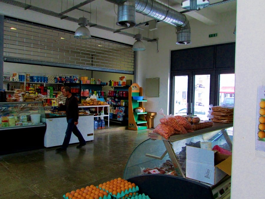 Inside the Ayios Antonios municipal market in Nicosia, with fresh produce, packaged goods and a shopper browsing the aisles
