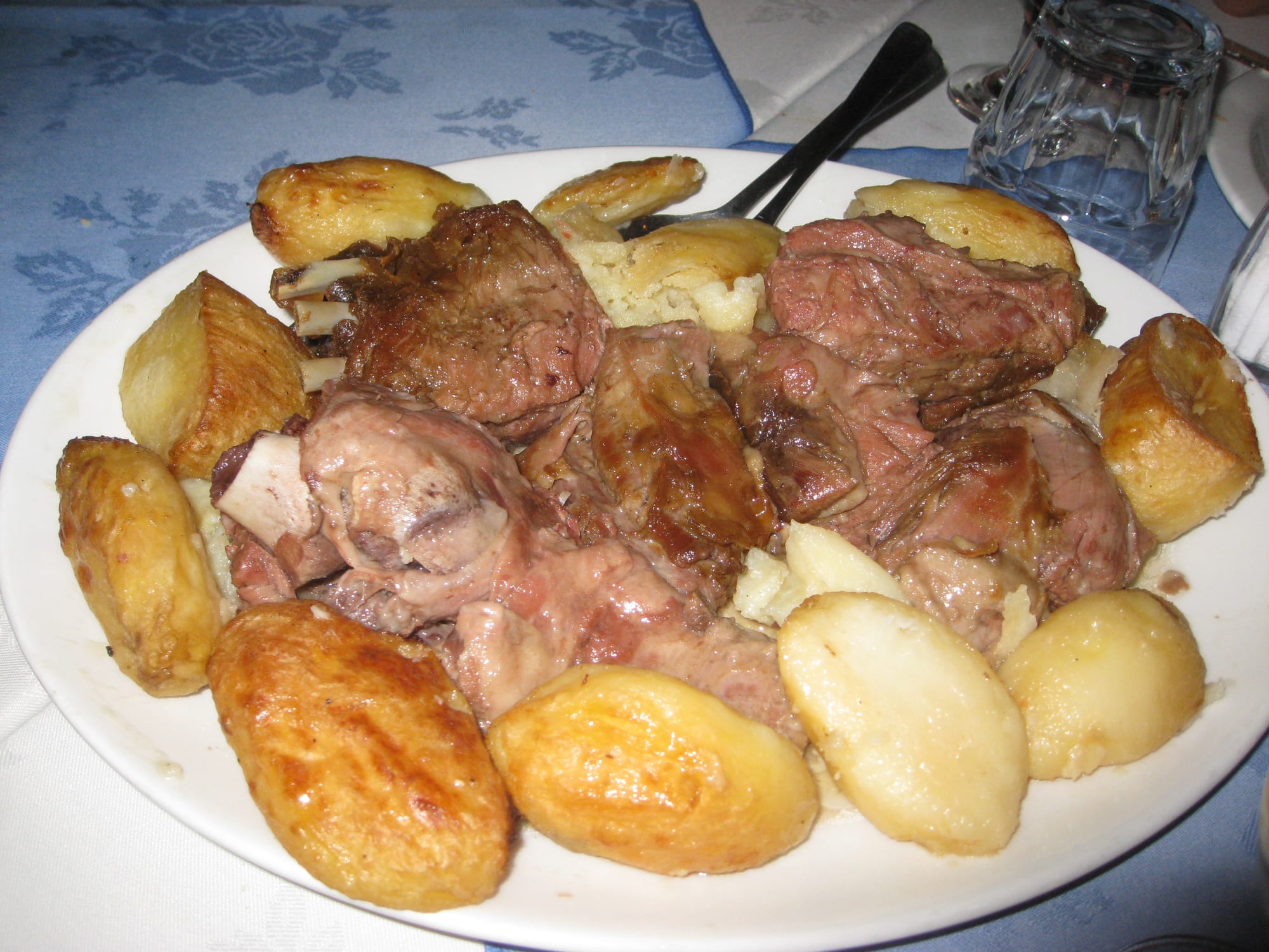 A portion of slow-cooked lamb falling apart on a plate