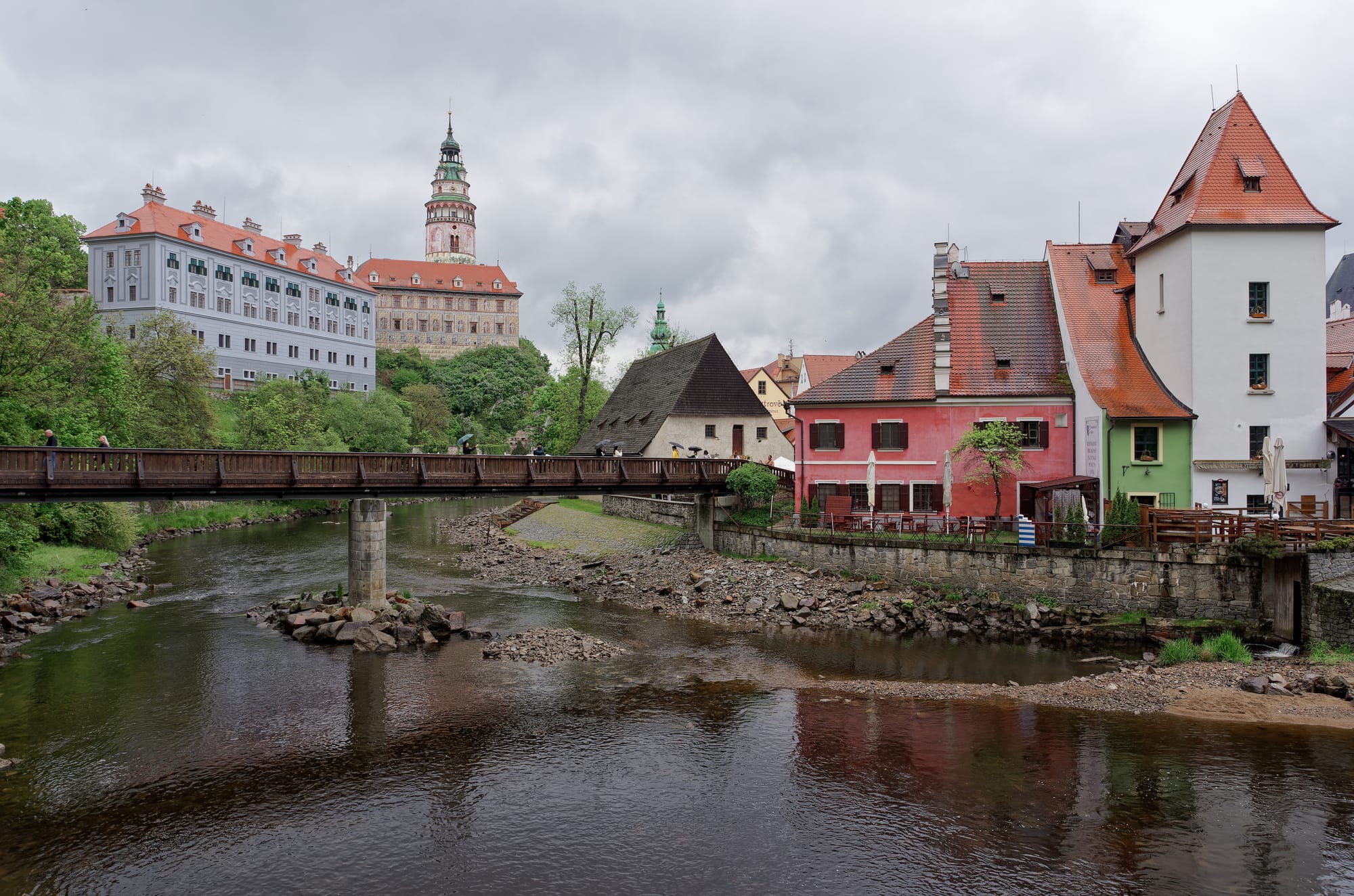 A painted castle tower and a huddle of medieval houses wrapped in a tight river bend