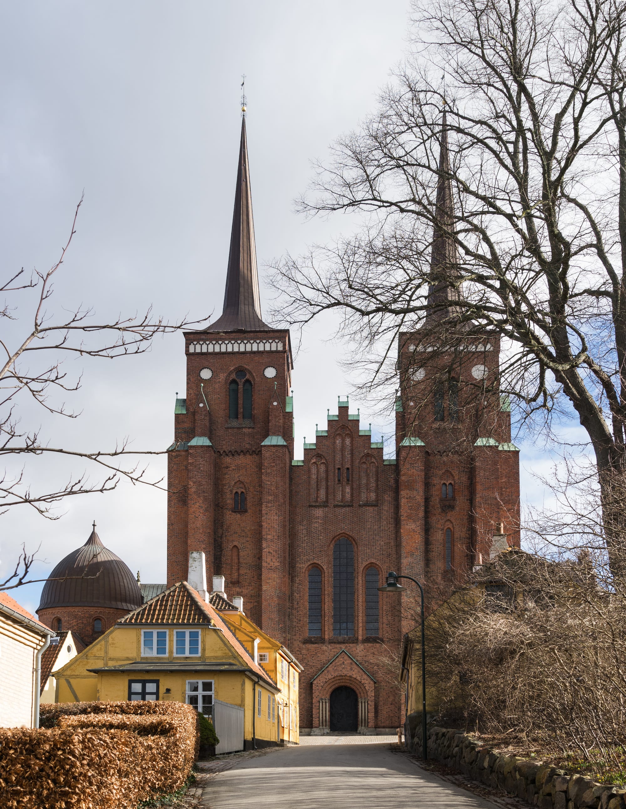 A tall twin-spired brick Gothic cathedral