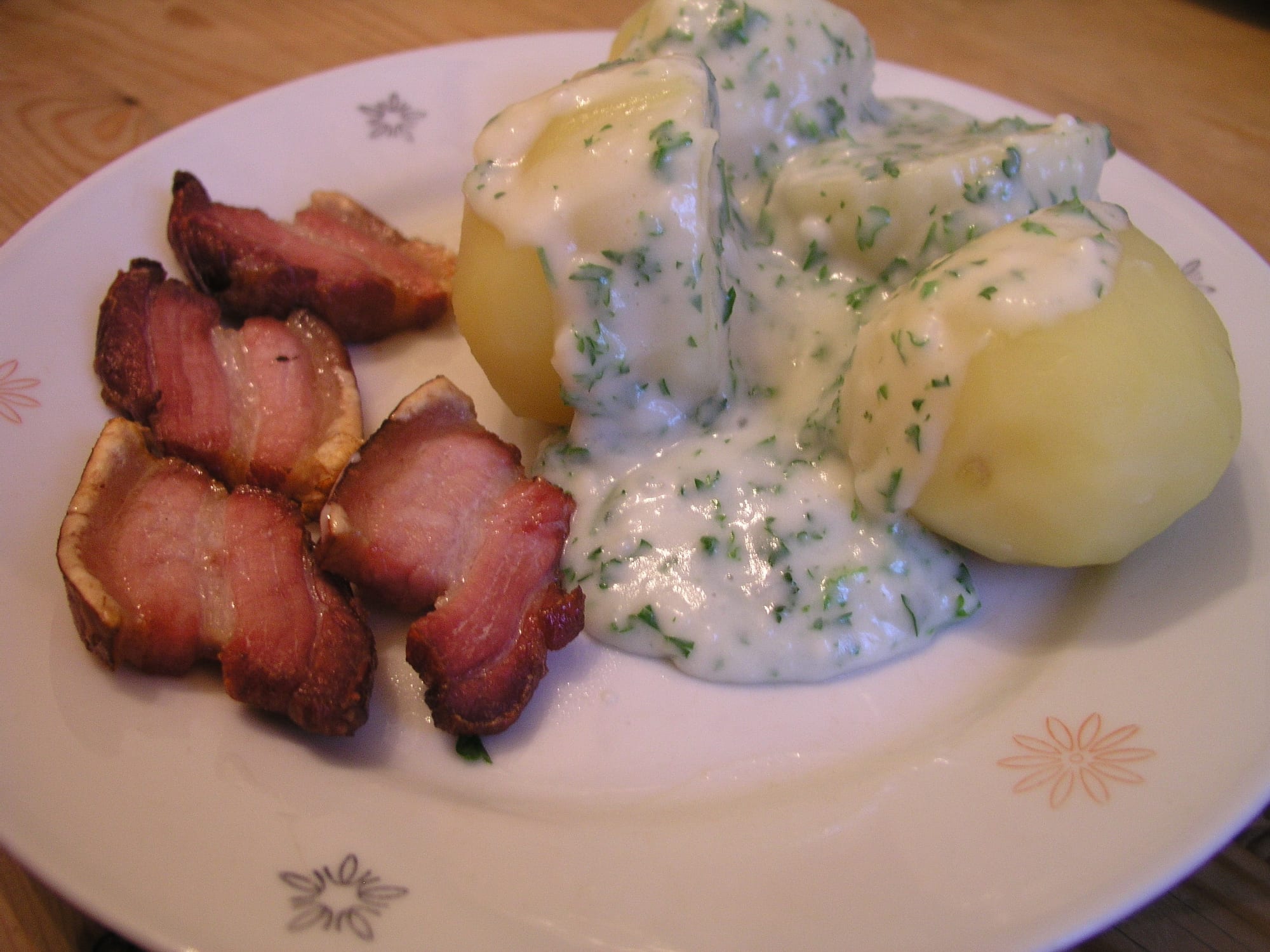 Fried slices of pork belly served with boiled potatoes and a creamy sauce with green herbs
