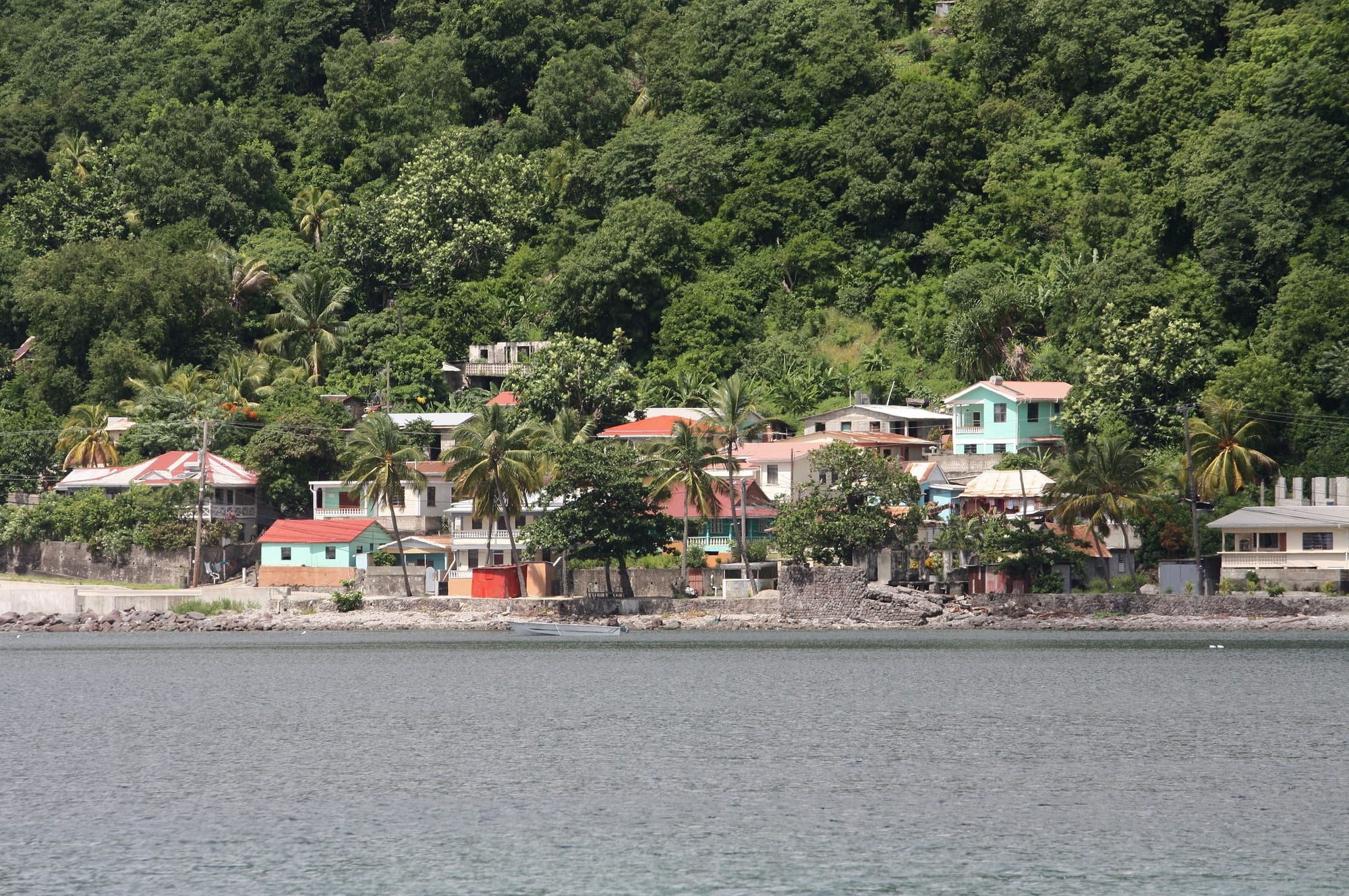 A narrow spit of land curving from the shore to a small hill, sea on both sides