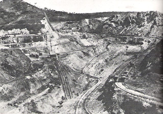 An early 20th-century photograph of an open copper mine with rail tracks and workers in Katanga