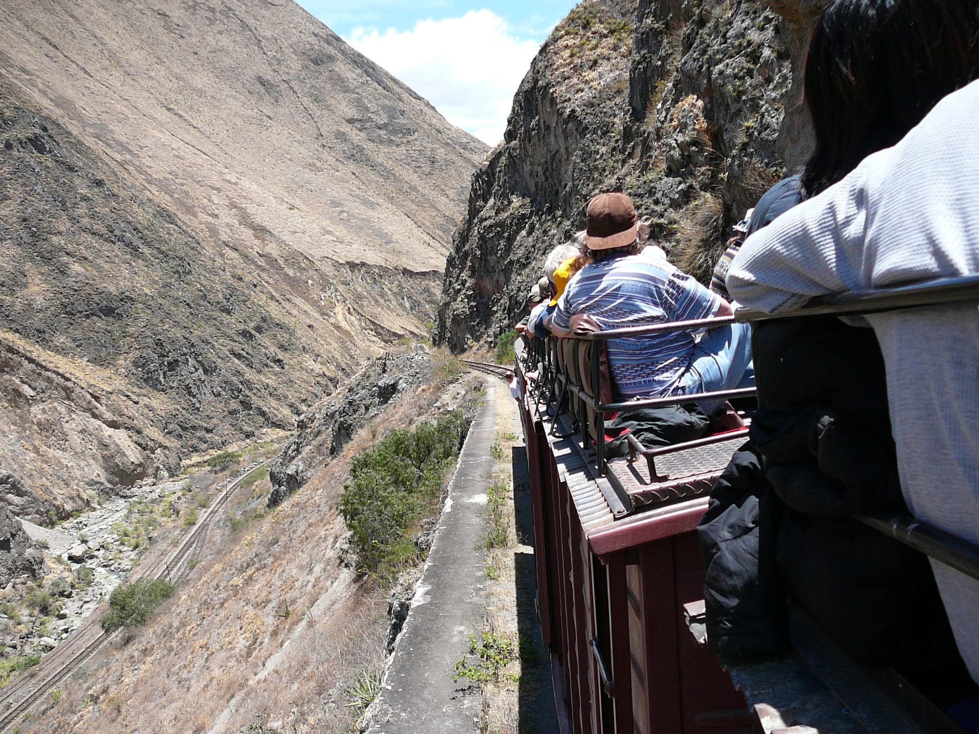 A railway line switchbacking down an almost vertical cliff face in a deep Andean valley