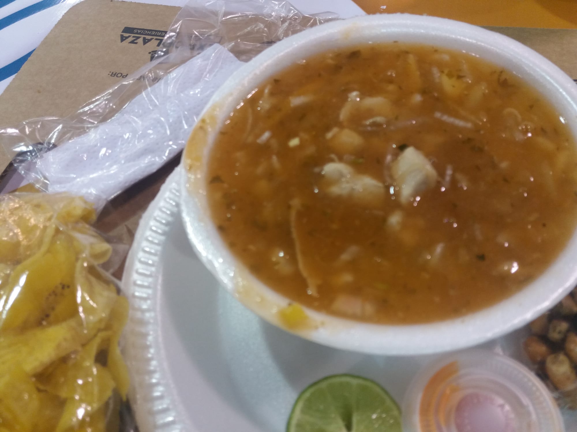 A bowl of fish soup with visible yuca, onion and herbs