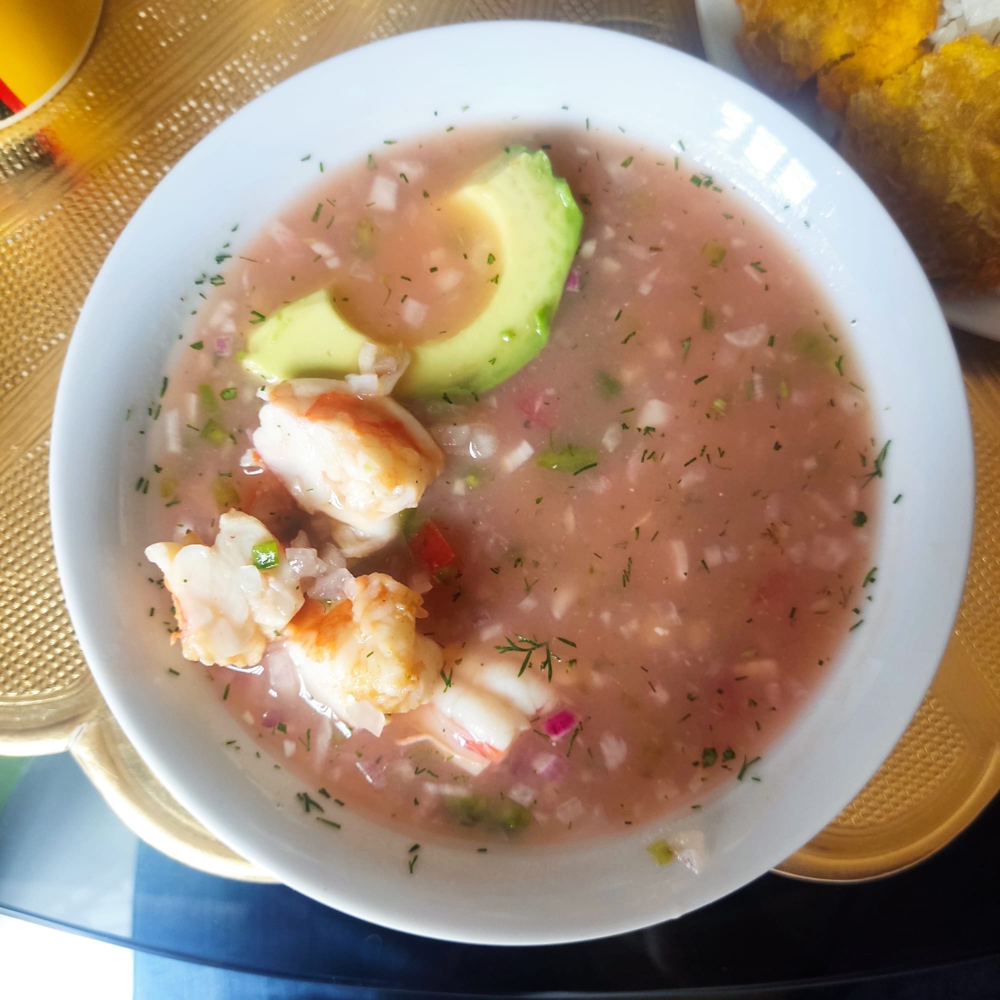 A bowl of shrimp in a reddish tomato-based marinade