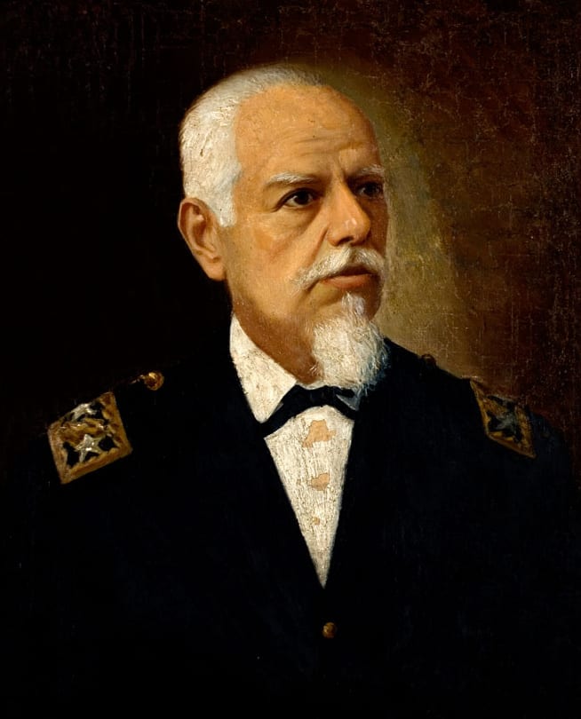 A late 19th-century portrait of Eloy Alfaro, a stern man with a full white beard in a dark coat