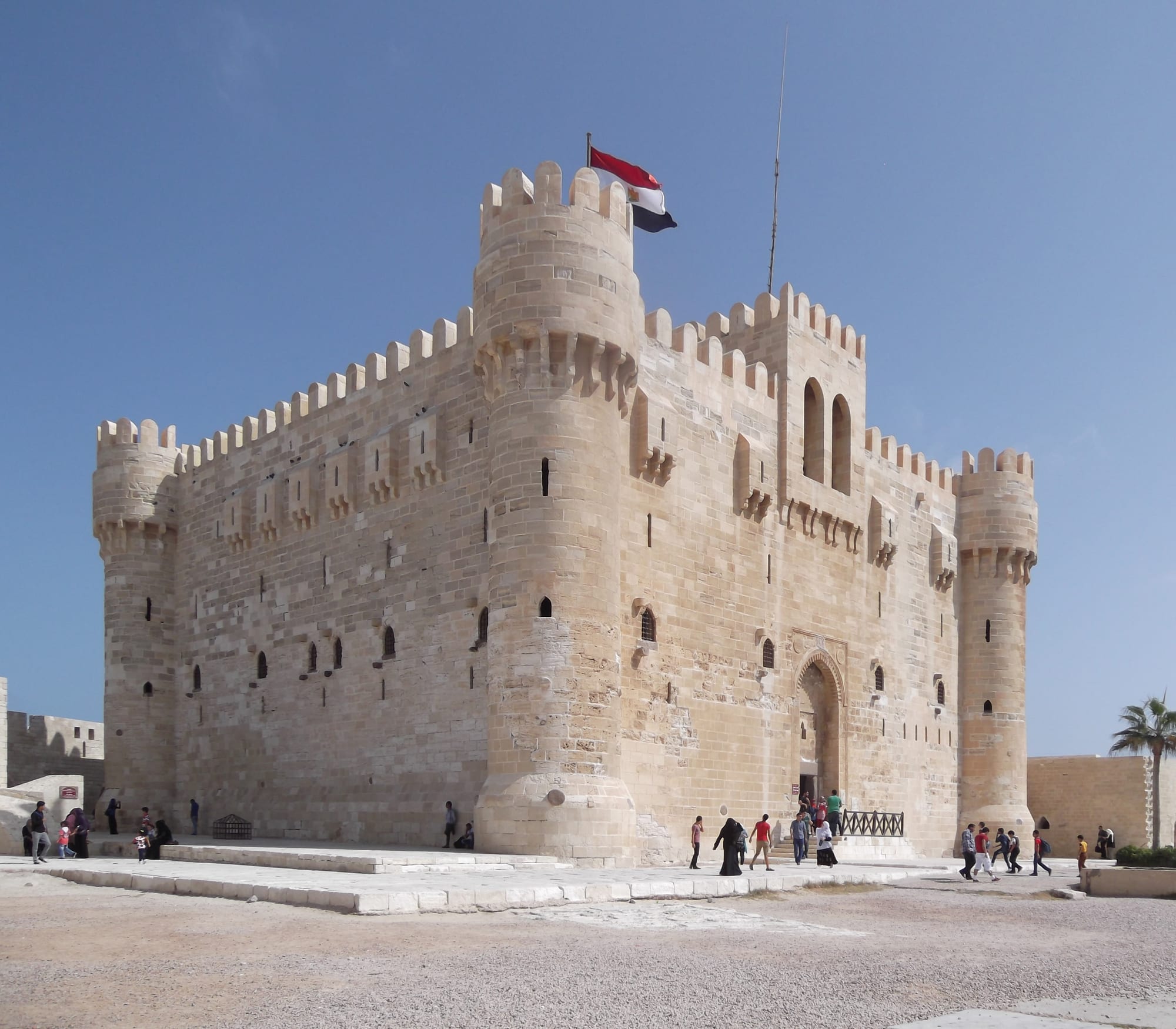 A sandstone medieval fortress with round towers on the Alexandria waterfront