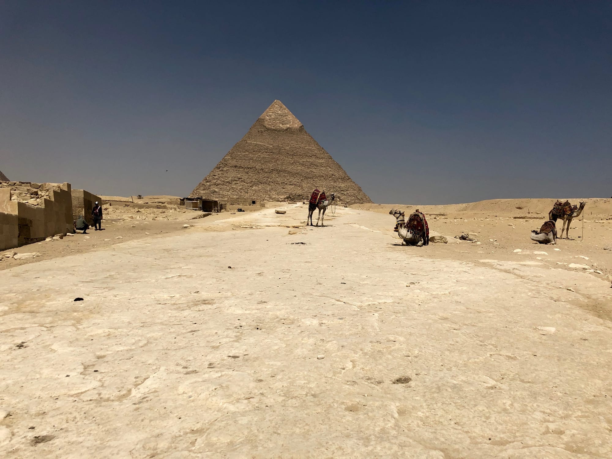 Two great stone pyramids and a smaller one rising from the desert on the edge of a city