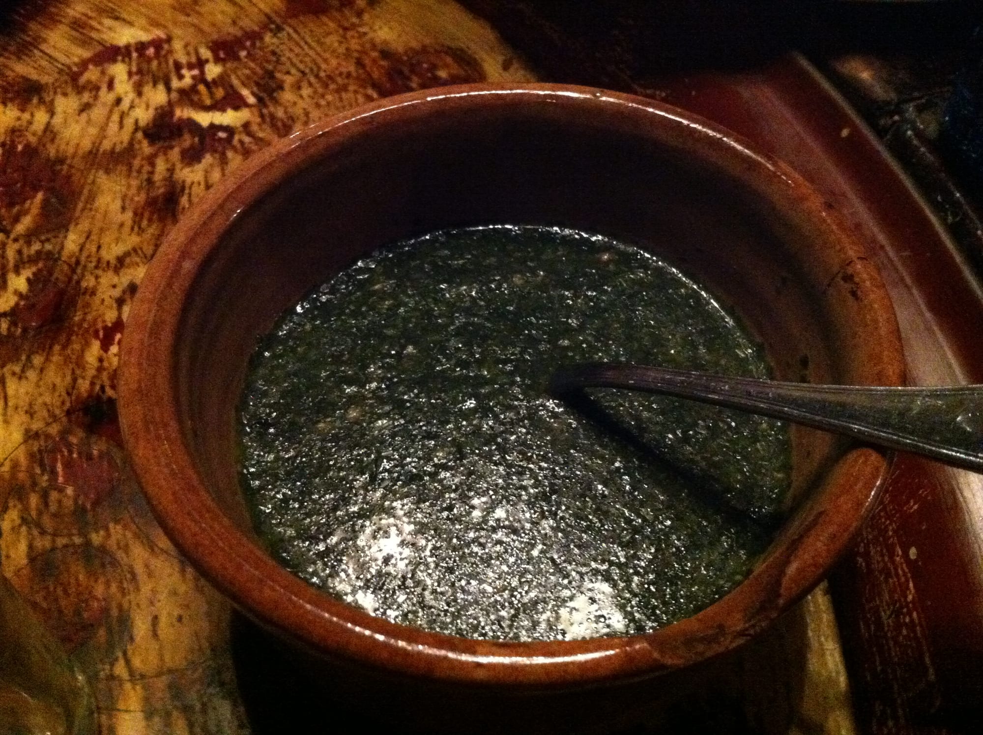 A dark green, thick soup served in a bowl