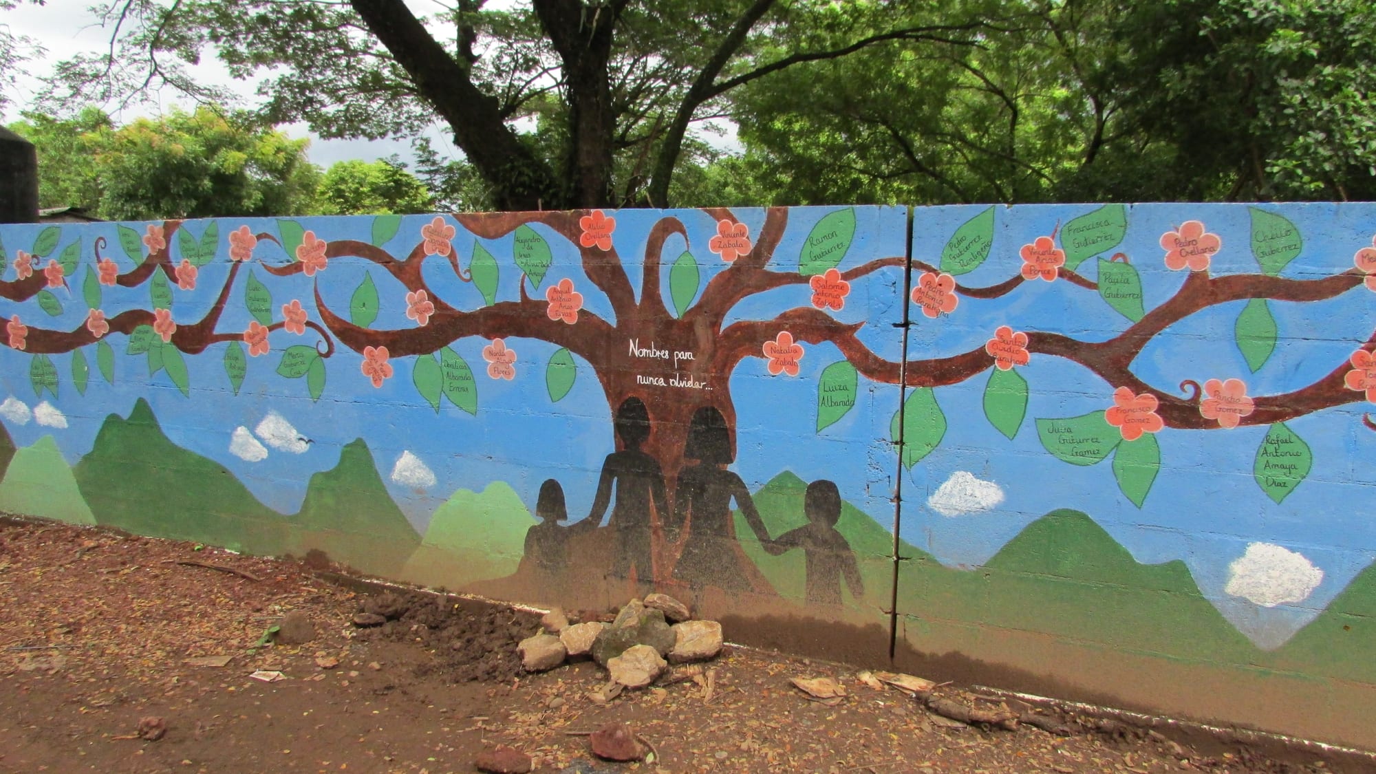 A colourful painted wall mural depicting guerrilla fighters, doves and rural scenes of the war years