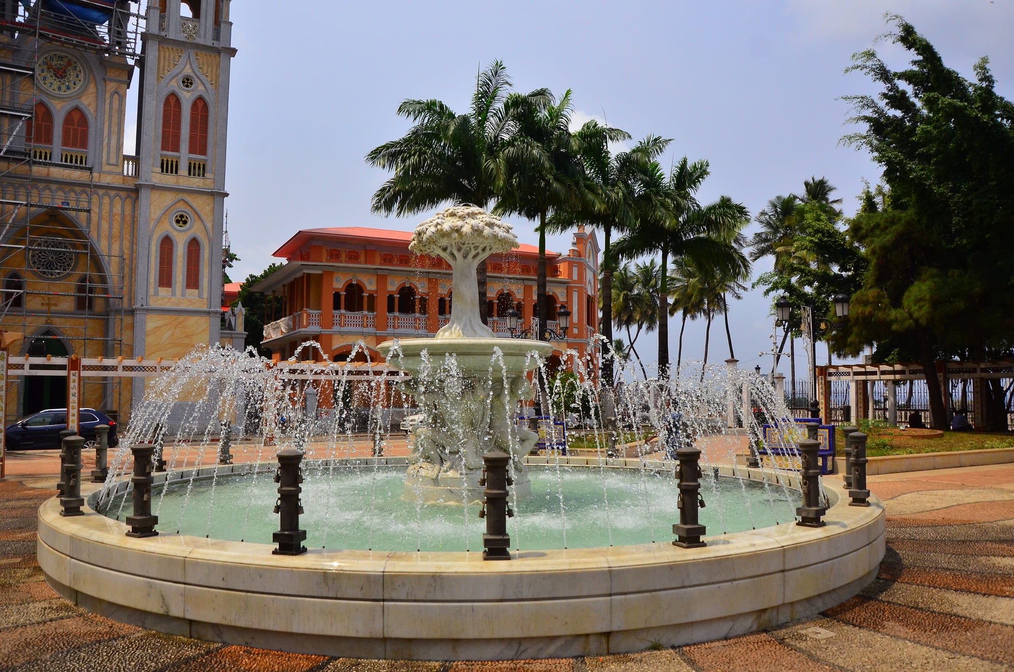 A street in a tropical capital with low colonial and modern buildings