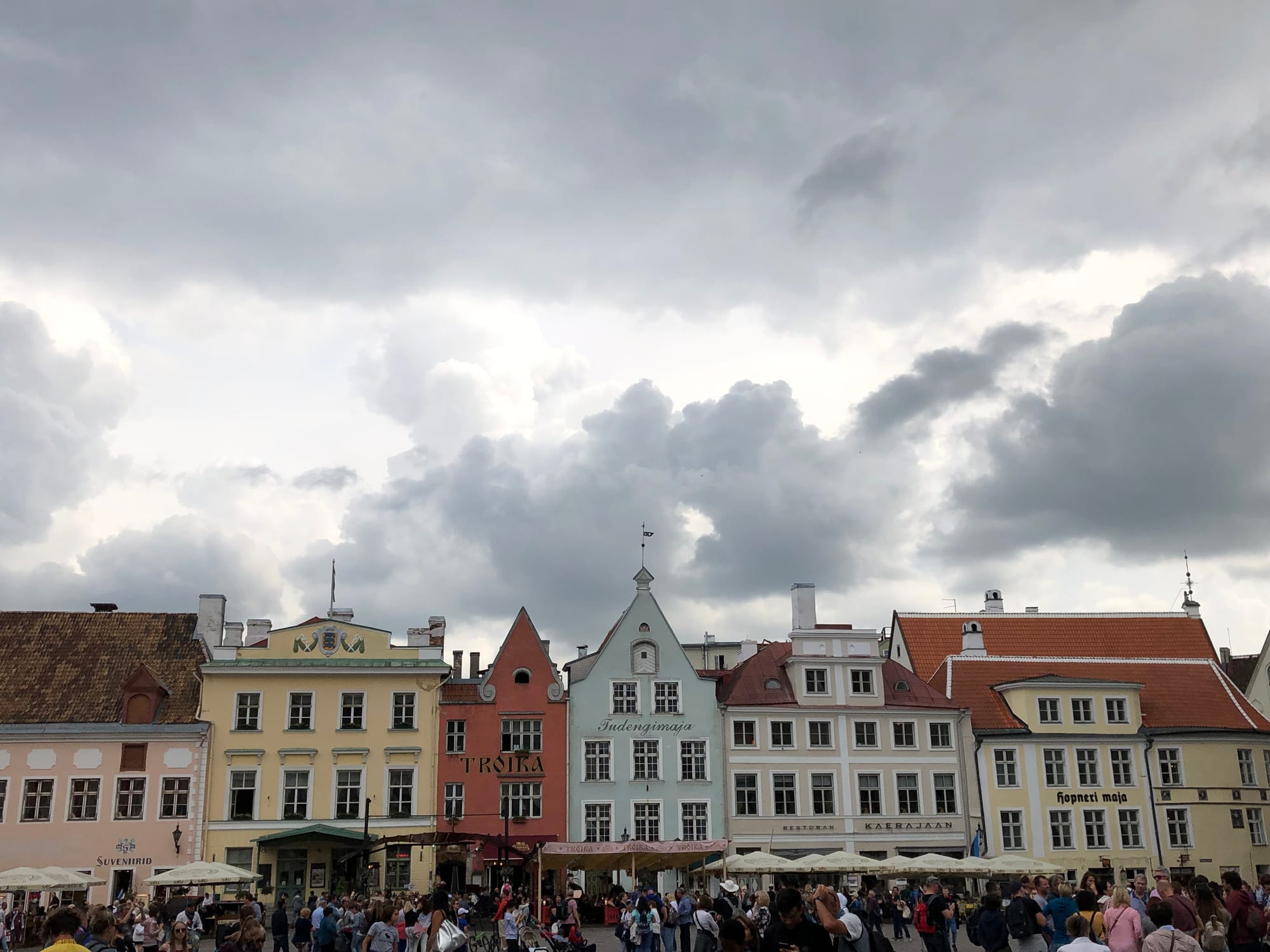 A skyline of red-tiled roofs, church spires and defensive towers inside a walled medieval town