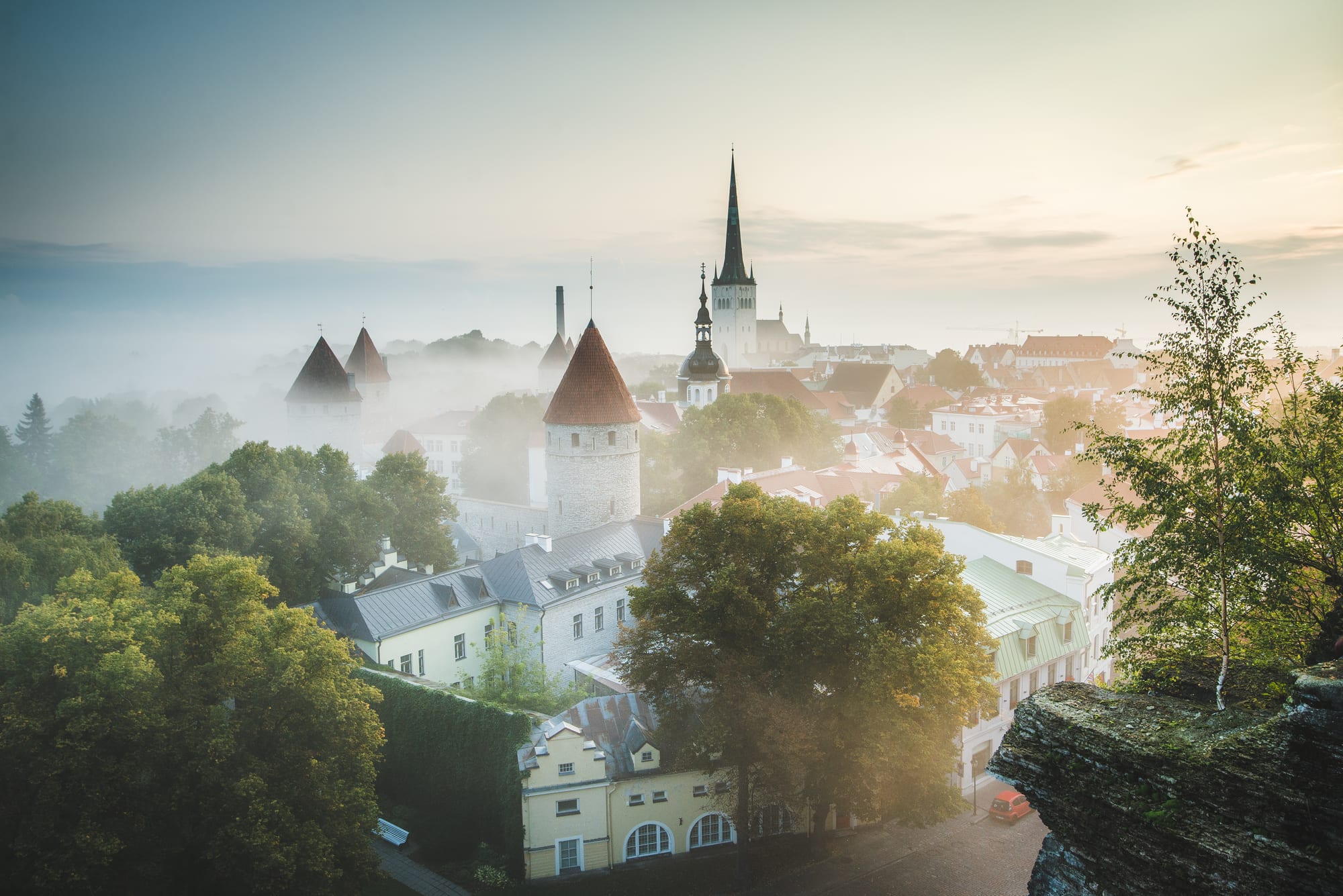 Red-tiled roofs, church spires and medieval towers of Tallinn's old town at sunrise