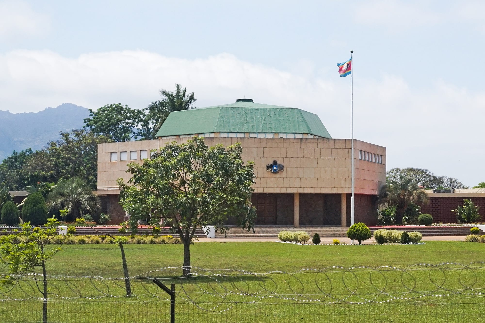 A low modern government building with flags in the royal village of Lobamba