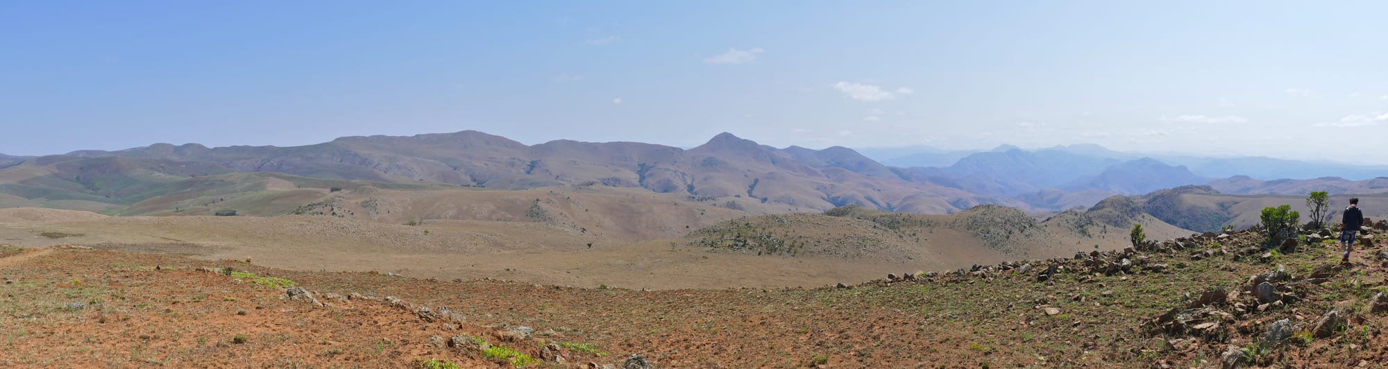 Rolling green mountain grassland and deep valleys under a big sky