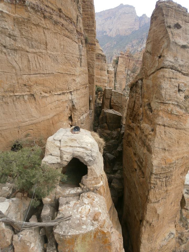 A small church built into a cliff face high on a sheer sandstone tower