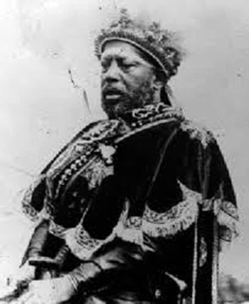 A painted portrait of Emperor Menelik II in a crown and richly embroidered robes