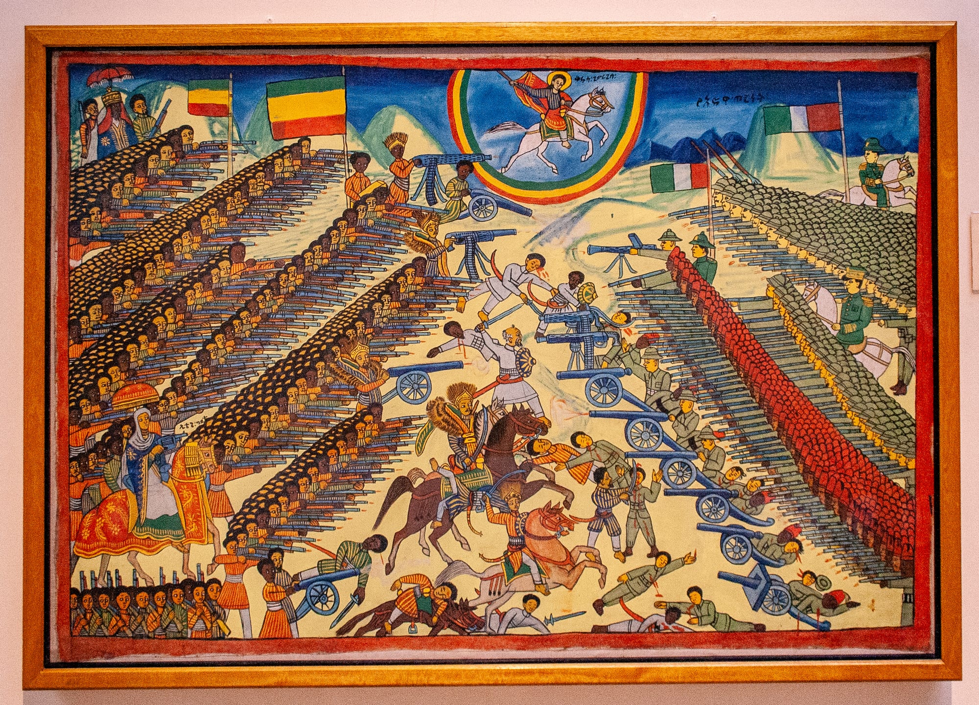 A vivid traditional Ethiopian painting of the Battle of Adwa, with ranks of soldiers, horses and Saint George overhead