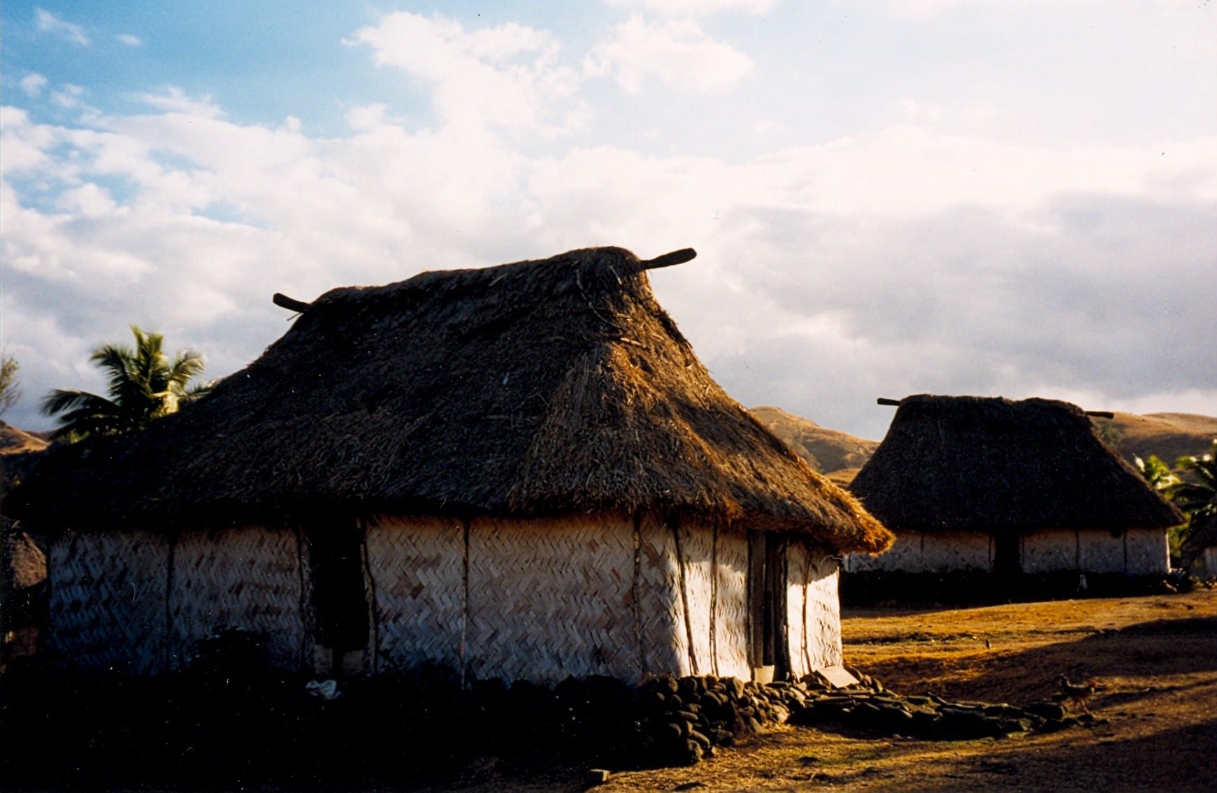 Rows of neat thatched houses with steep roofs in a green highland valley