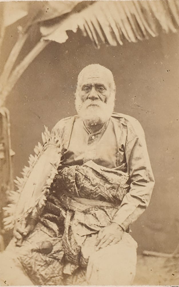 A photographic portrait of Cakobau around 1875, an elderly Fijian man in a dark jacket