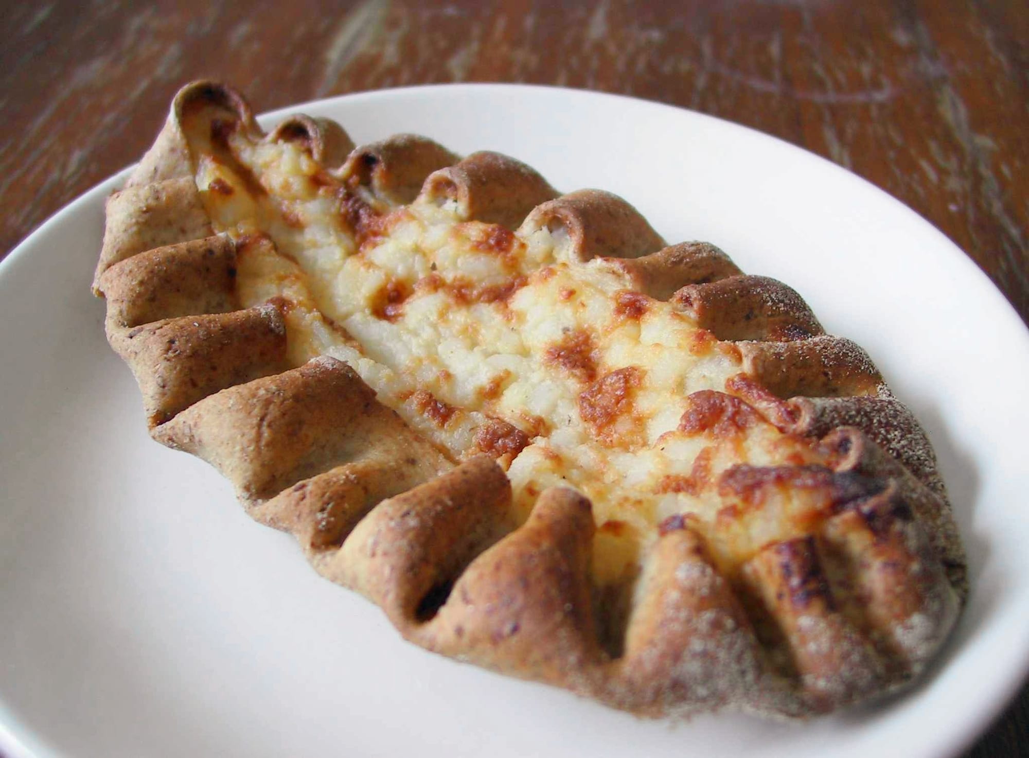 Small oval pastries with a rye crust arranged on a plate