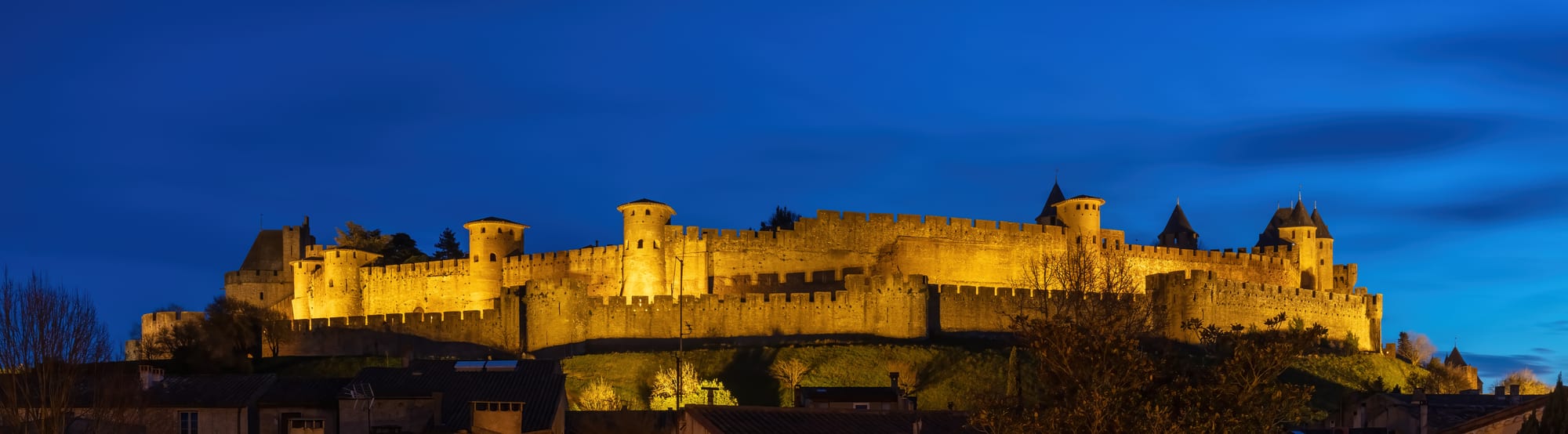 A double-walled medieval fortress town with dozens of round towers on a hill