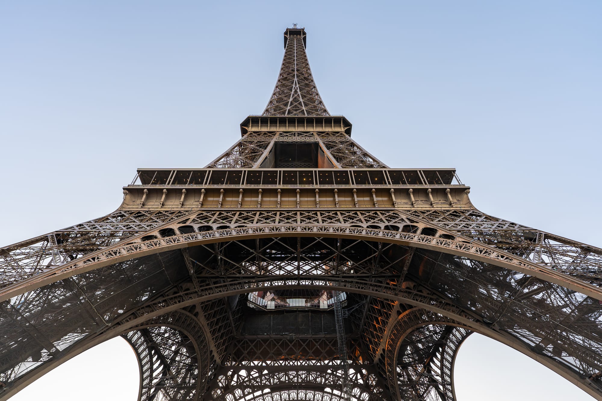 The Eiffel Tower seen from below against a clear sky