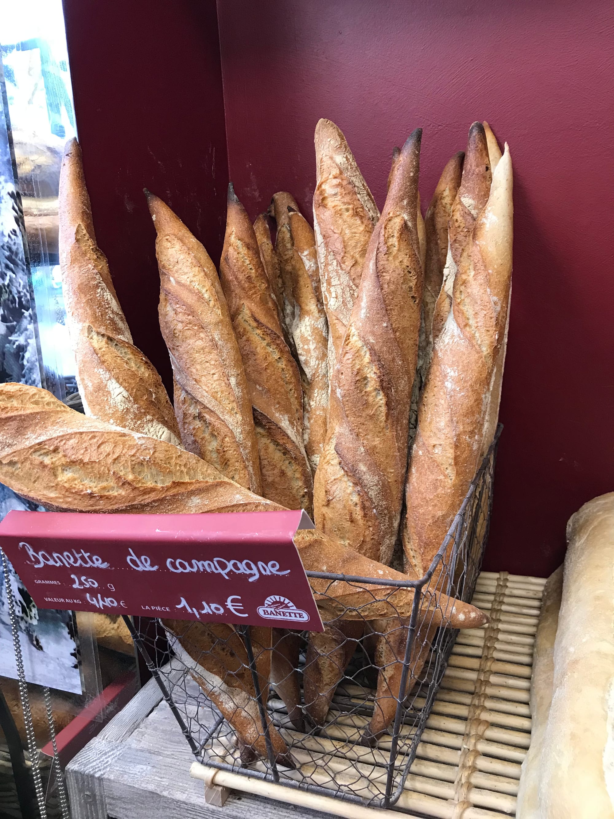 Rows of fresh baguettes on display in a bakery