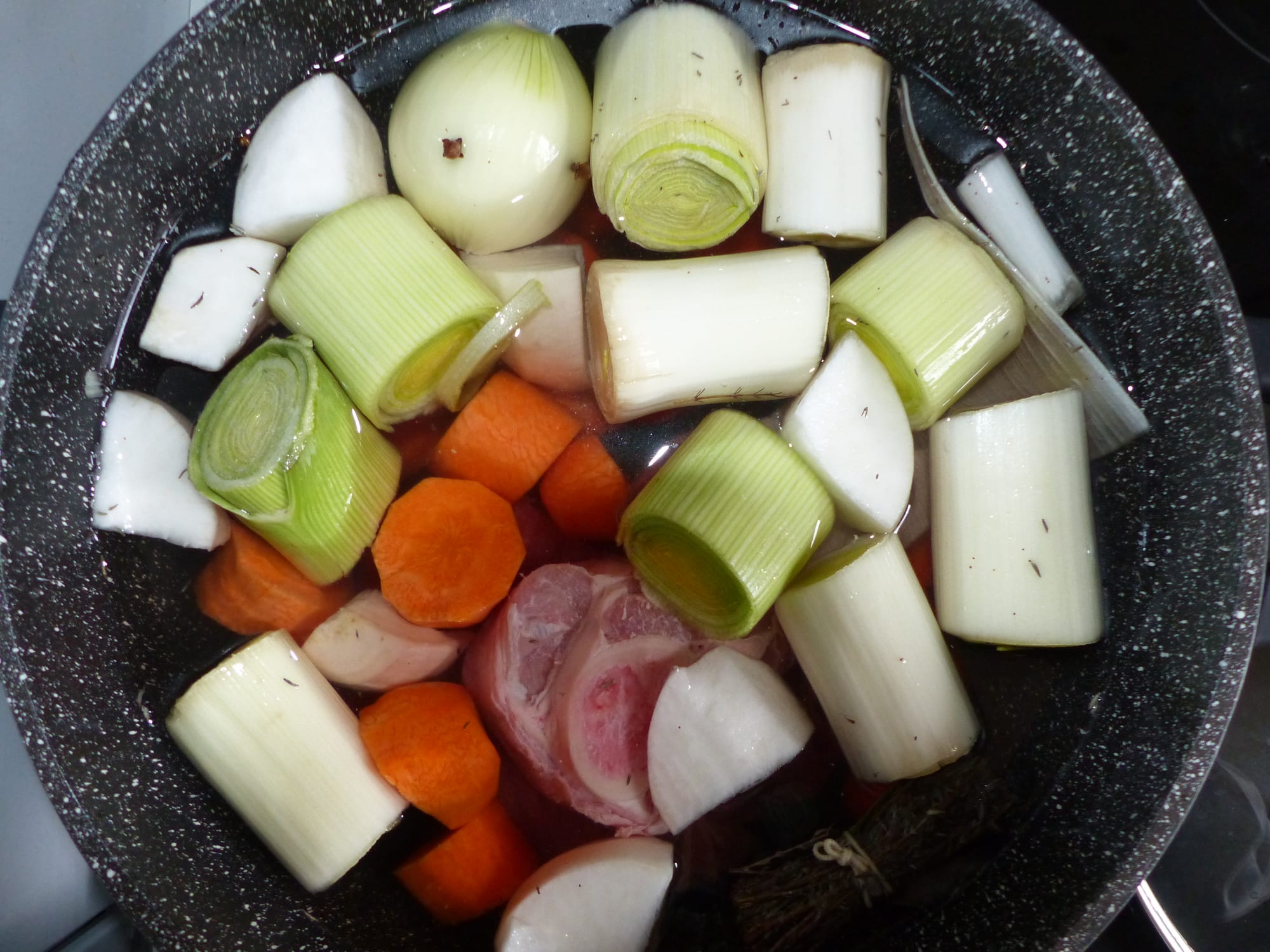 Chunks of beef and whole vegetables laid out before cooking