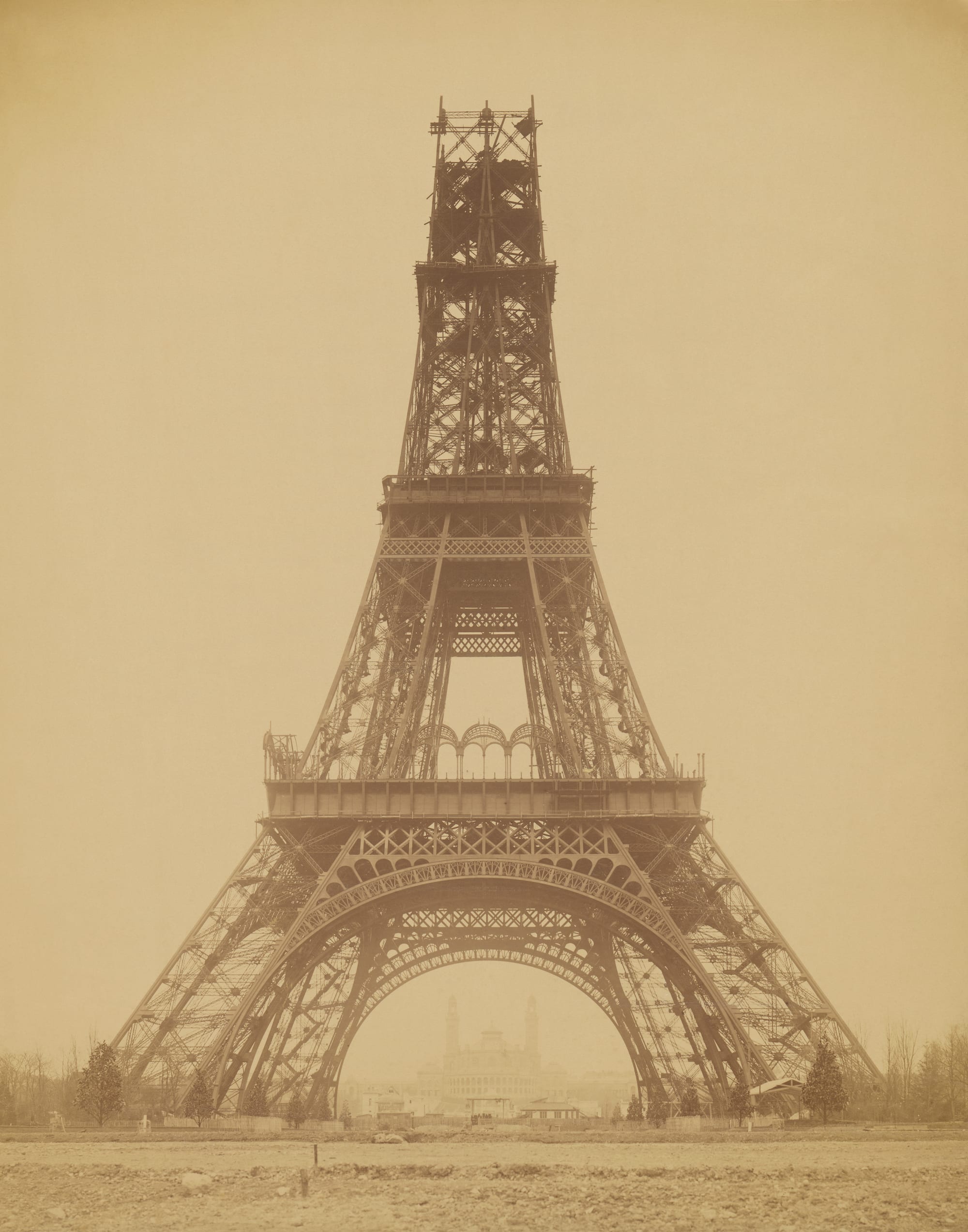 The half-built iron Eiffel Tower rising above Paris buildings in an 1888 photograph