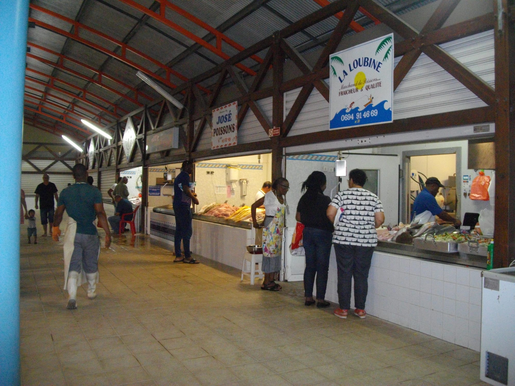 A busy covered market with fish stalls and shoppers