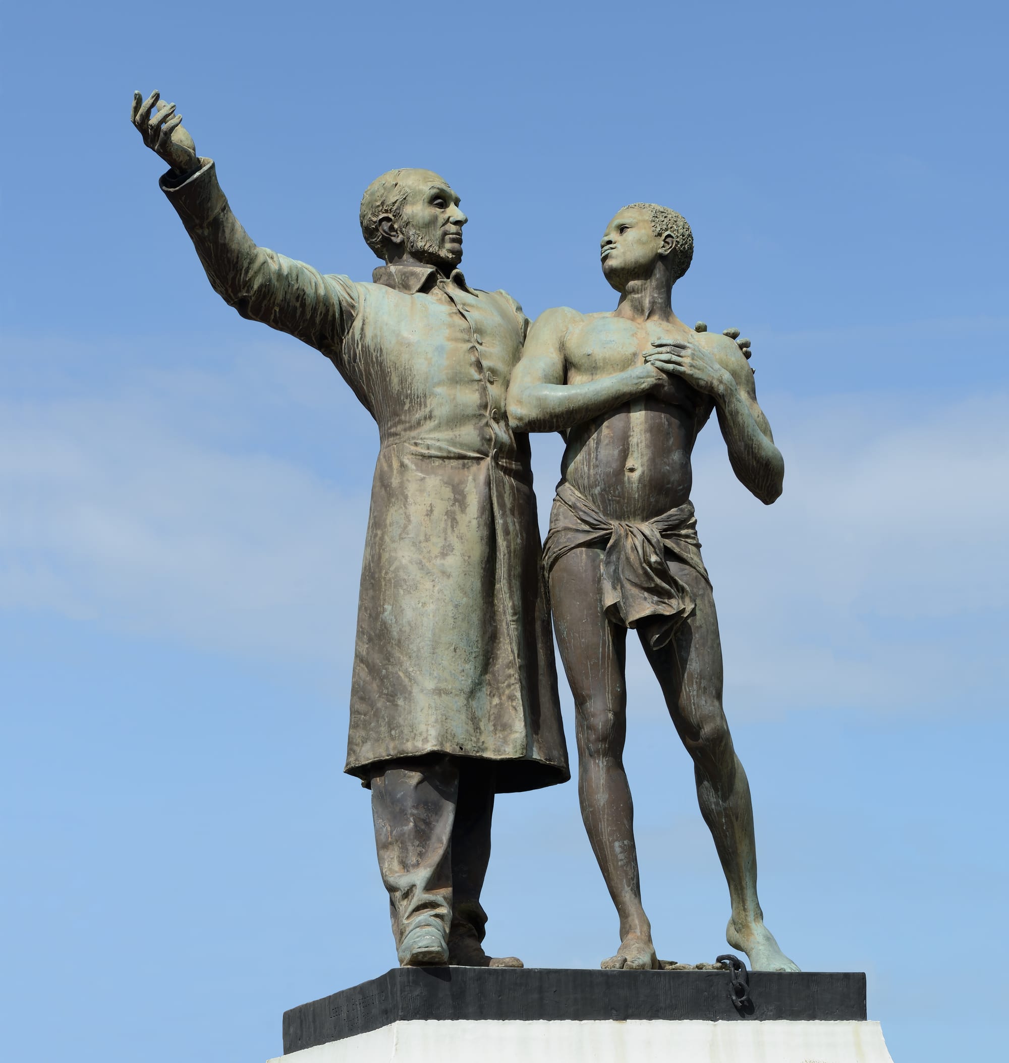 A bronze statue of Victor Schœlcher with a freed enslaved child, on a stone plinth in Cayenne